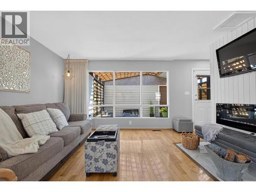 Bright and inviting living room with large windows, plenty of natural light, and a comfortable layout perfect for relaxing or spending time with family. - 1261 Lawson Avenue, Kelowna, BC 