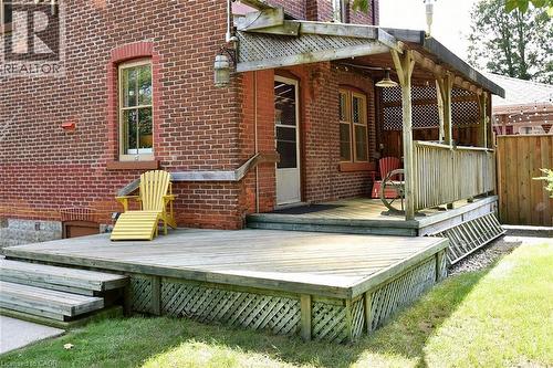 Expansive wood deck with lattice skirting, leading to a covered porch with wood railing and lattice accents - 781 Oakdale Avenue, Burlington, ON 