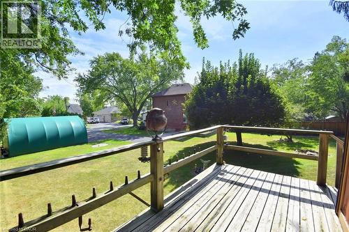 Expansive outdoor deck with wood railing, overlooking a large grassy area and mature trees - 781 Oakdale Avenue, Burlington, ON 