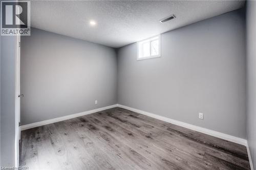 Neutral painted walls, recessed lighting, wood-finish flooring, and a white window - 33 Ruskview Road Unit# Lower, Kitchener, ON 