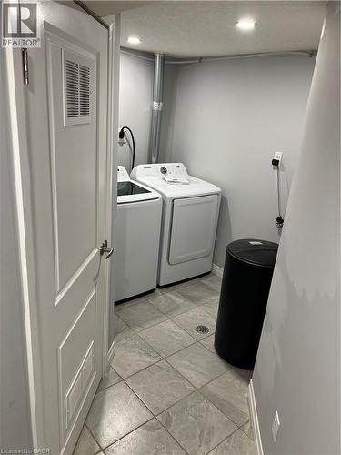 Laundry area featuring ceramic tile flooring, recessed lighting, and a paneled door - 33 Ruskview Road Unit# Lower, Kitchener, ON 