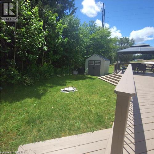 Expansive green lawn, elevated wood-finish deck with steps, freestanding gazebo, and a storage shed - 580 Beaver Creek Road Unit# Lot 158, Waterloo, ON 