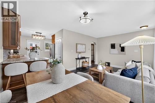 Open-concept living space with dark wood-finish flooring, recessed lighting, and neutral wall tones - 176 Avalon Place, Kitchener, ON 