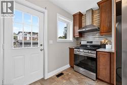 Stainless steel range with coordinating ventilation hood, tile backsplash, wood-finish cabinetry, and solid surface countertops - 