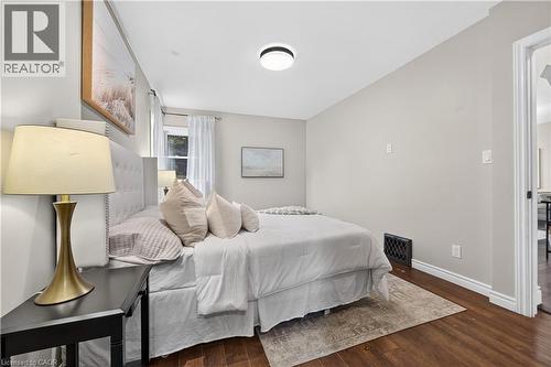 Wood-finish flooring with white baseboards, a window with sheer curtains, and a flush mount ceiling light - 176 Avalon Place, Kitchener, ON 