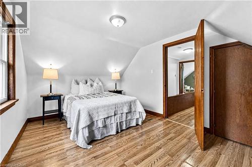 Wood-finish flooring, white walls, angled ceiling, wood trim, and a flush mount ceiling light - 176 Avalon Place, Kitchener, ON 