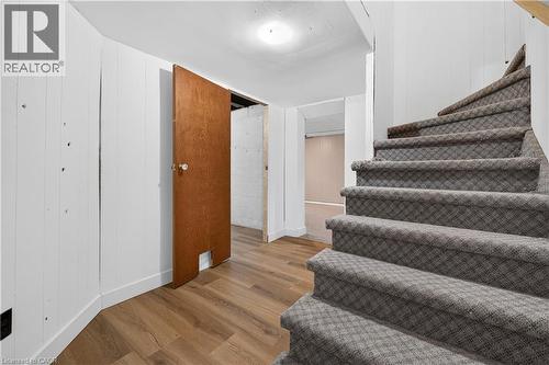 Wood-finish flooring, white paneled walls, and carpeted staircase - 176 Avalon Place, Kitchener, ON 