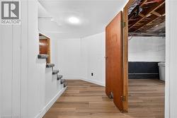 Wood-finish flooring, white paneled walls, and recessed lighting - 