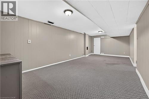 Expansive room featuring wall paneling, ceiling-mounted lighting, and carpet flooring - 176 Avalon Place, Kitchener, ON 
