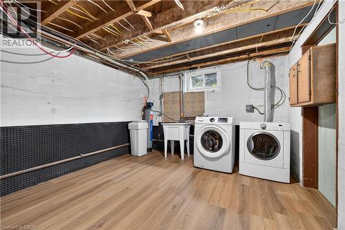 Wood-finish flooring with white block walls and a utility sink - 176 Avalon Place, Kitchener, ON 