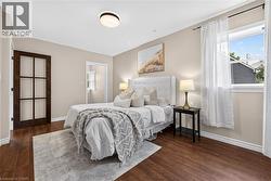 Wood-finish flooring throughout, light neutral paint, and a modern flush-mount ceiling light - 