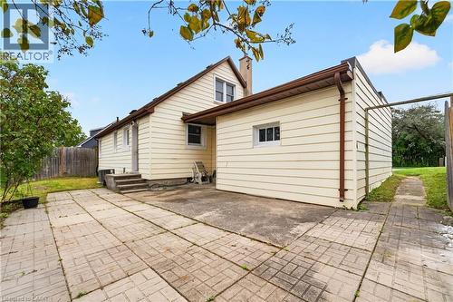 Exterior featuring light-toned siding, a multi-level roofline, and a concrete patio - 176 Avalon Place, Kitchener, ON 
