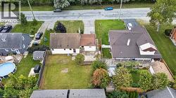Expansive green lawn with mature trees and a paved driveway - 