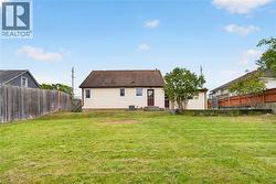 Expansive grassy yard with wood fencing and a detached structure - 