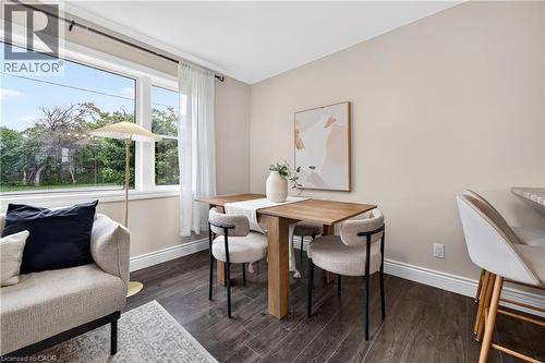 Large picture window, wood-finish flooring, neutral wall tones, white trim, and a breakfast bar - 176 Avalon Place, Kitchener, ON 