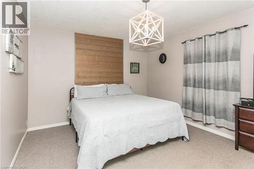 Geometric pendant light fixture, wood-finish accent wall, and neutral wall color - 393 Huron Street, New Hamburg, ON 