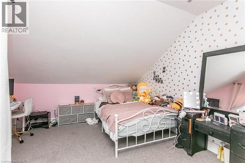 Wall-to-wall carpeting with a sloped ceiling and a partial accent wall with polka dot detailing - 393 Huron Street, New Hamburg, ON 
