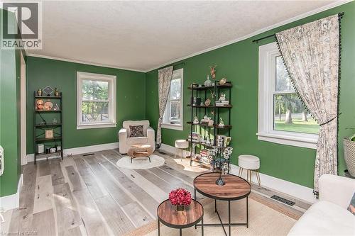 Wood-finish flooring, multiple windows, crown molding, and a built-in shelving unit - 393 Huron Street, New Hamburg, ON 