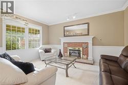 Red brick fireplace with a white mantel, white wainscoting, crown molding, and grid-pattern windows - 