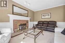 Brick-faced fireplace with a white mantel, crown molding, track lighting, and wainscoting - 