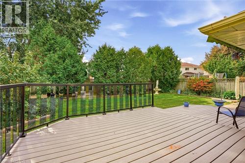 Expansive backyard featuring a composite deck with glass panel railing and a manicured lawn - 5 Michelle Drive, St. Catharines, ON 
