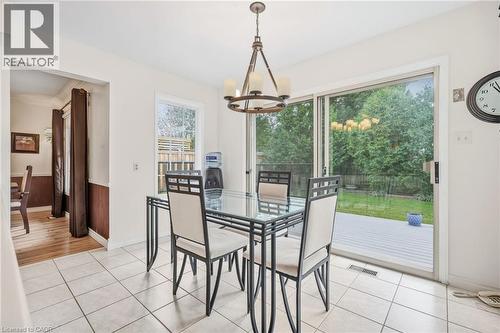 Tiled flooring, pendant lighting fixture, sliding glass door, white trim window, and wood paneling in an adjoining space - 5 Michelle Drive, St. Catharines, ON 
