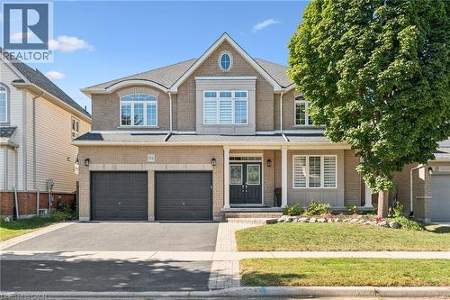 Brick exterior with stone accents, covered front entry, double garage, and paved driveway - 154 Falconridge Drive, Kitchener, ON 