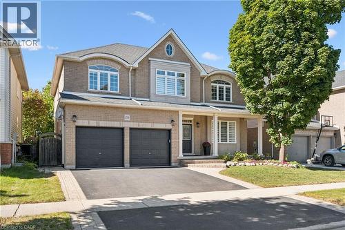 Brick facade with a covered entry and dual garage doors - 154 Falconridge Drive, Kitchener, ON 
