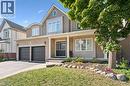 Brick facade with stone accents, two-car garage, covered porch entry, double front doors, and a landscaped front yard - 154 Falconridge Drive, Kitchener, ON 