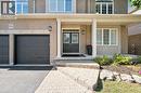 Brick exterior with a covered porch, double entry doors, two-car garage, and stone paver walkway - 154 Falconridge Drive, Kitchener, ON 
