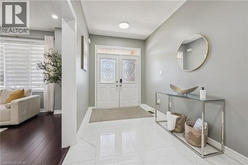 Entryway featuring a double door with decorative glass inserts, transom window, recessed lighting, and large format tile flooring - 154 Falconridge Drive, Kitchener, ON 