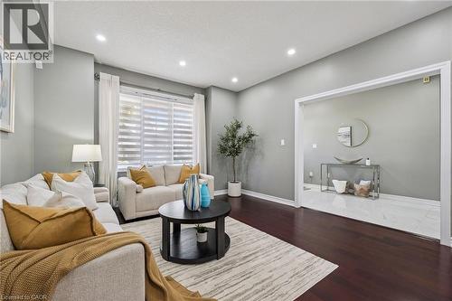 Recessed lighting illuminates the living space with dark wood-finish flooring - 154 Falconridge Drive, Kitchener, ON 