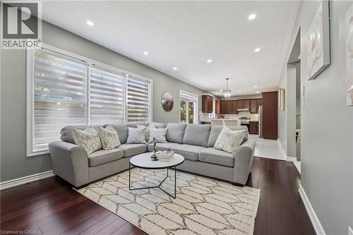 Hardwood flooring, recessed lighting, expansive windows, kitchen with shaker-style cabinetry, and pendant light fixture - 154 Falconridge Drive, Kitchener, ON 