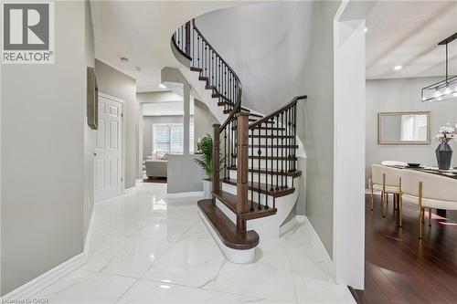 Curved staircase with wood treads and wrought iron balusters - 154 Falconridge Drive, Kitchener, ON 