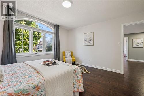 Arched top window with multiple panes, dark wood-finish flooring, and light-colored walls - 154 Falconridge Drive, Kitchener, ON 
