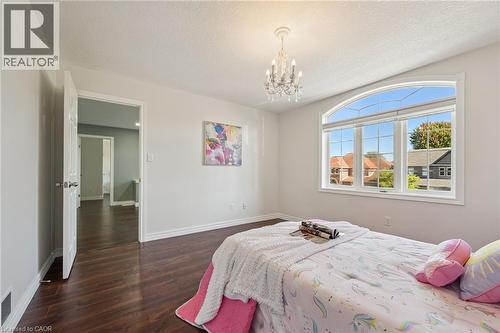 Arched window with gridded panes, crystal chandelier, and wood-finish flooring - 154 Falconridge Drive, Kitchener, ON 