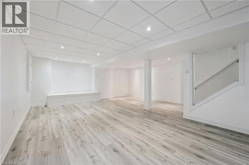 Spacious interior featuring light wood-finish flooring, recessed lighting, drop ceiling, and a built-in bench - 154 Falconridge Drive, Kitchener, ON 