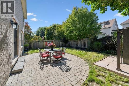 Paved patio with a curved edge, brick exterior, and a fenced perimeter - 154 Falconridge Drive, Kitchener, ON 