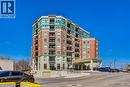 Multi-story building featuring brick and stone exterior, extensive window glazing, and individual balconies - 2750 King Street E Unit# 103, Hamilton, ON 