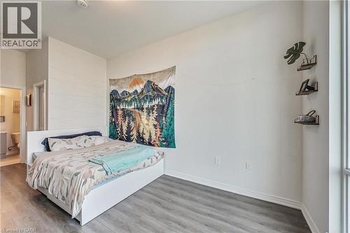 Spacious room featuring wood-finish flooring, white walls, and a recessed ceiling light - 2750 King Street E Unit# 103, Hamilton, ON 