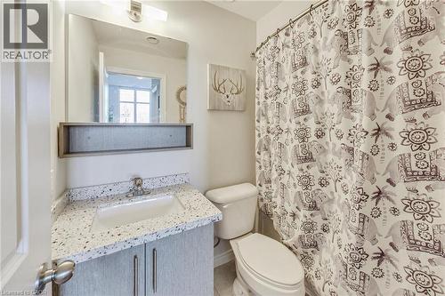 Vanity with a speckled countertop, undermount sink, and two-door cabinetry - 2750 King Street E Unit# 103, Hamilton, ON 