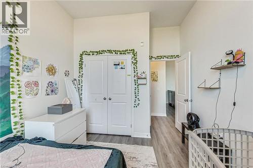 High ceilings, wood-finish flooring, two-panel interior doors, and a built-in closet with double doors - 2750 King Street E Unit# 103, Hamilton, ON 