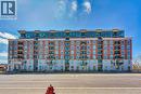 Brick facade building featuring multiple balconies, a ground-level entrance, and upper-level glass balconies - 2750 King Street E Unit# 103, Hamilton, ON 
