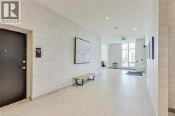 Modern corridor featuring light-toned tile flooring, recessed lighting, expansive windows, and textured wall coverings - 