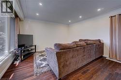 Recessed lighting, crown molding, wood-finish flooring, and a large window - 