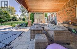 Covered patio with a wood-plank ceiling, brick exterior wall, and stone-finish flooring - 