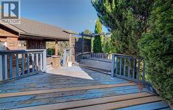 Expansive outdoor deck with integrated hot tub, privacy screening, and mature perimeter trees - 