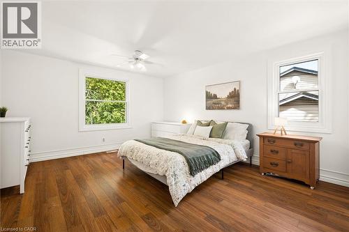Wood-finish flooring with white baseboards, two windows with white trim, and a ceiling fan - 351 Craigleith Drive, Waterloo, ON 