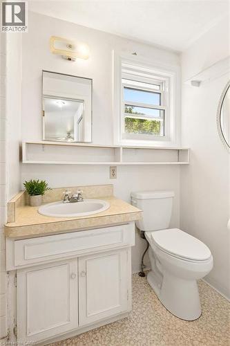 Bathroom featuring a single vanity with a laminate countertop, a white porcelain sink, and a framed wall mirror - 351 Craigleith Drive, Waterloo, ON 