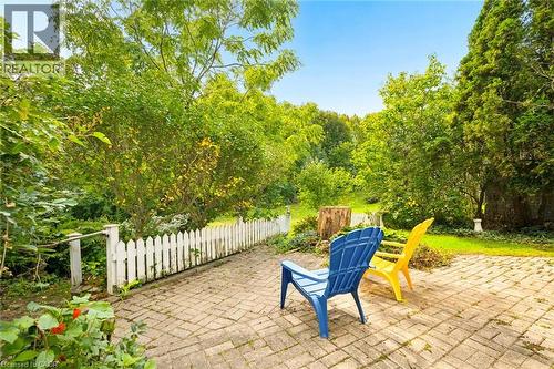 Brick paver patio with a white picket fence and abundant mature landscaping - 351 Craigleith Drive, Waterloo, ON 